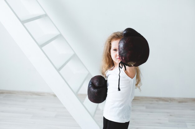 Funny little girl in boxing gloves. Winner.