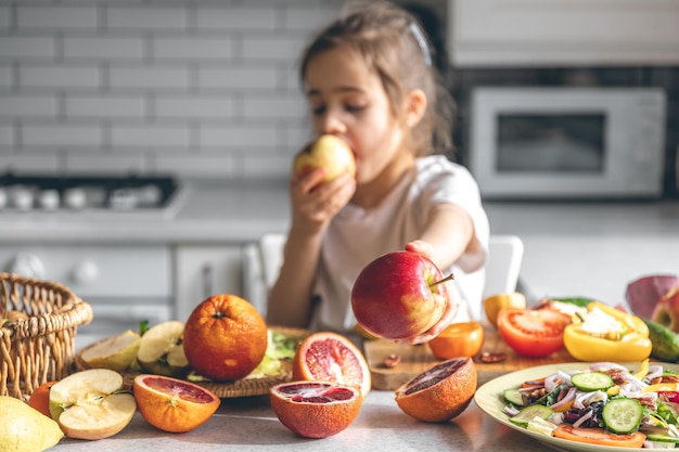 写真 キッチンの健康と栄養の概念でリンゴを食べる面白い少女