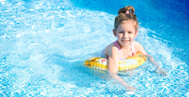 Funny little girl swimming in the pool