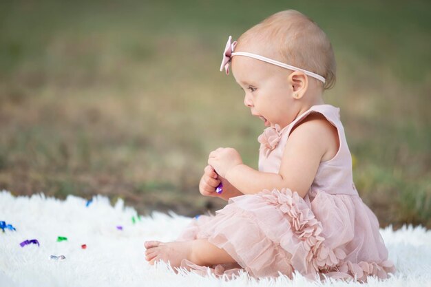 Funny little girl on a walk in a summer park One year old child Sweet baby