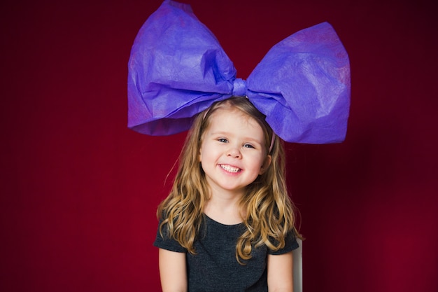 Photo funny little girl with big bow on head