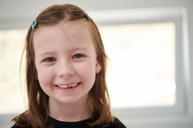 Photo funny little girl without tooth smiles showing gap close up