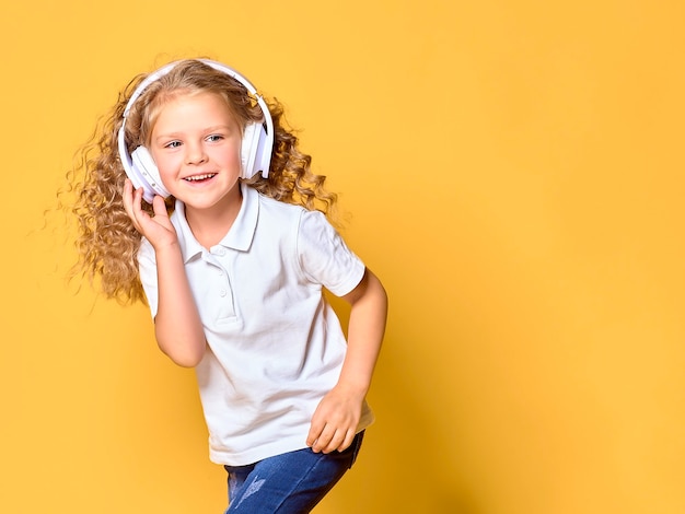 Funny little kid girl in white t-shirt isolated on yellow space