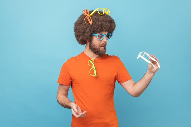 Funny man choosing colorful eyeglasses holding white spectacles choosing the best color