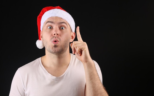 Funny man in a santa hat on a black background