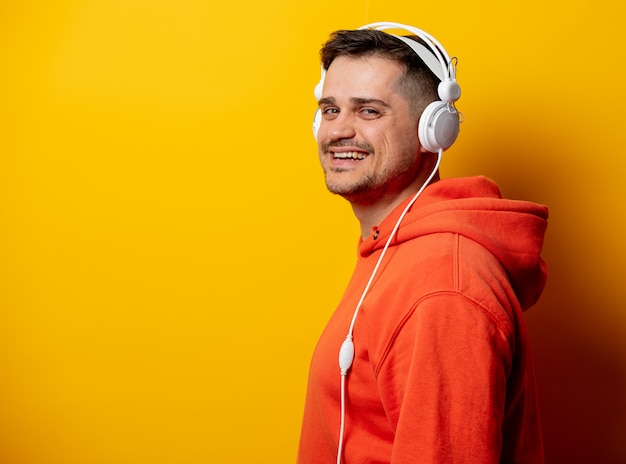 Funny man with headphones on yellow wall