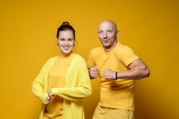 Funny man and woman stand in bizarre poses and strange
faces