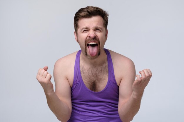 Funny mature man in sport clothes shows tongue