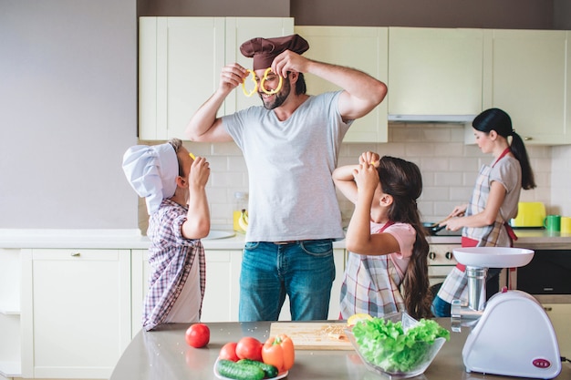 Divertenti membri della famiglia stanno giocando con il cibo.