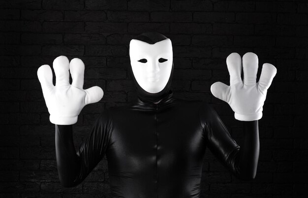 Photo funny mime in a white mask on a black background