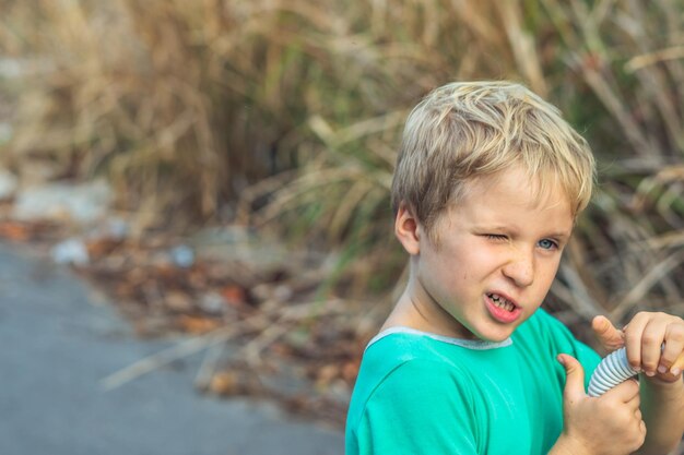 Funny mischievous cute blond boy freckles face squints winks artistic emotions gesturing Behaviour education micro moments joys of happy childhood compassion toward humanity and society concept