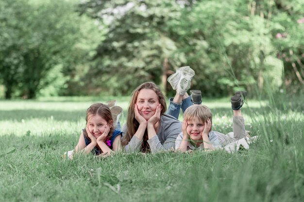 Funny mom with her kids on the lawn on a summer day