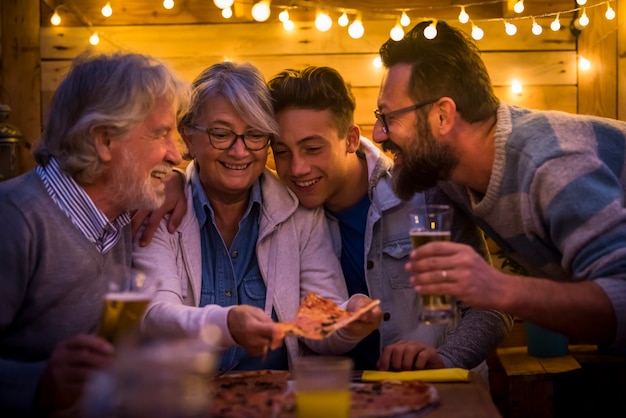 Funny moment of family at dinner eating pizza and drinking beer together - christmas night and new year party