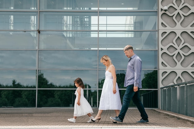 Funny moments of walk on summer family day with daughter. Mom and daughter are dressed in white cotton dresses. Happy family. Natural materials. Happy relationship. Right way of life. Father's day