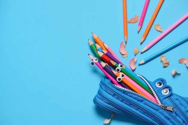 Photo funny pencil case eating pencils on blue