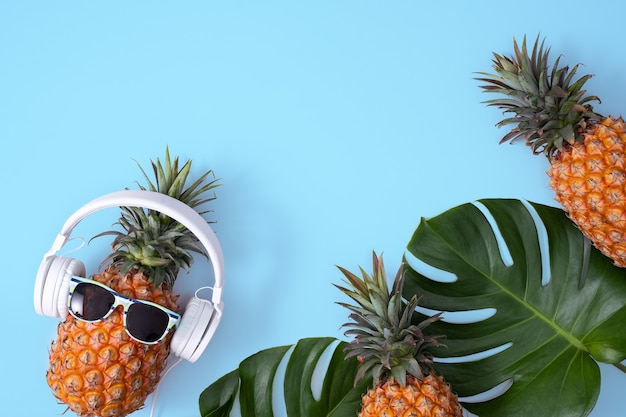 Funny pineapple wearing white headphone, concept of listening music