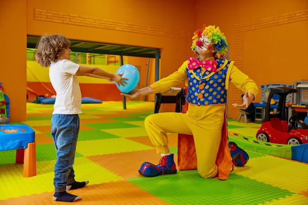 Foto giochi divertenti con il clown nella sala giochi coperta per bambini