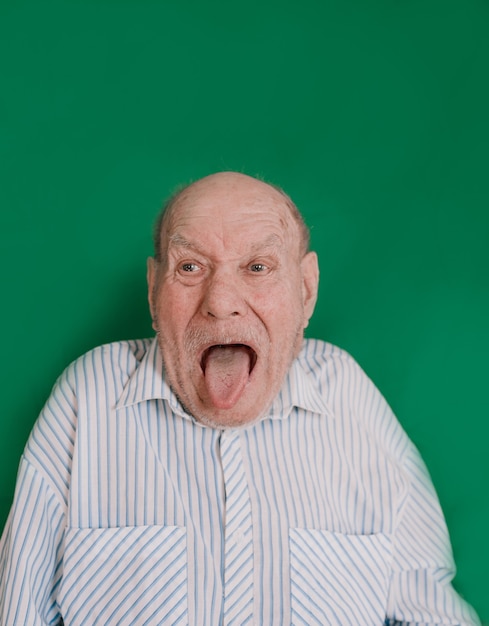 Funny portrait of an elderly man on a green background