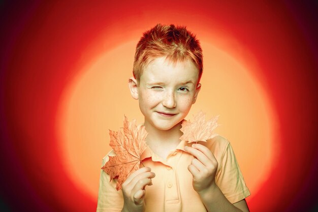 Funny redhead boy holding Autumn leaves Little child enjoy childhood Black friday shopping Happy cut