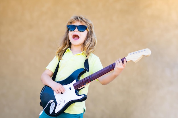 Funny rock child with guitar little boy in sunglasses kids music concept rock and roll guitar boy gu