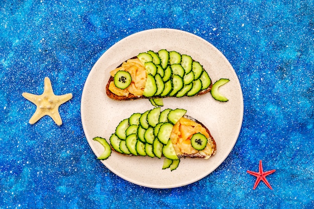 Funny salmon sandwiches with cucumber in fish shape