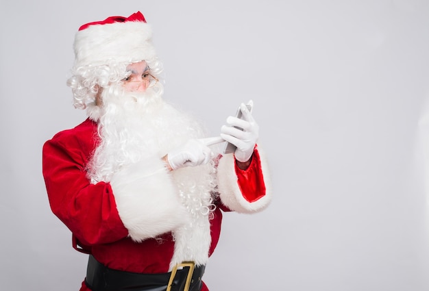 Foto babbo natale divertente in un costume rosso con un telefono