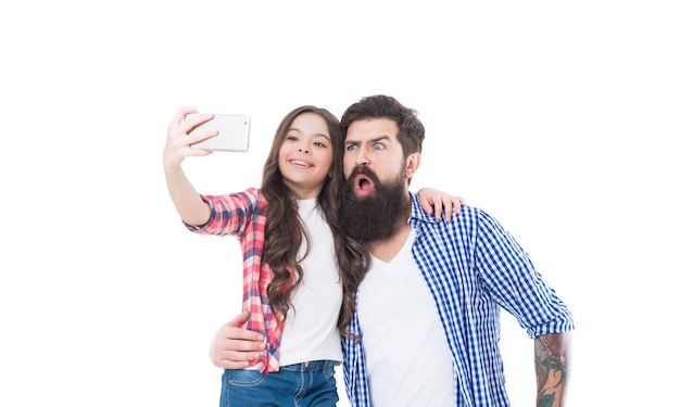 Funny selfie with dad Girl child and bearded man take selfie with smartphone Happy family