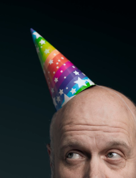 Funny senior bald man with party hat