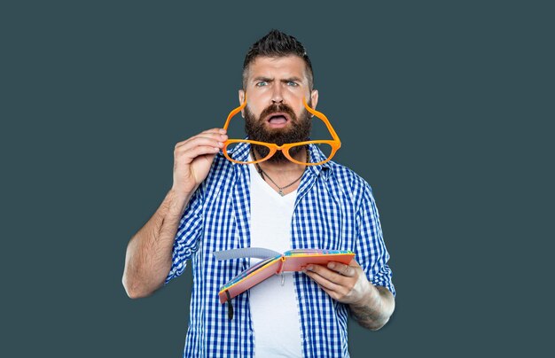 Funny shocked man in party glasses reading book