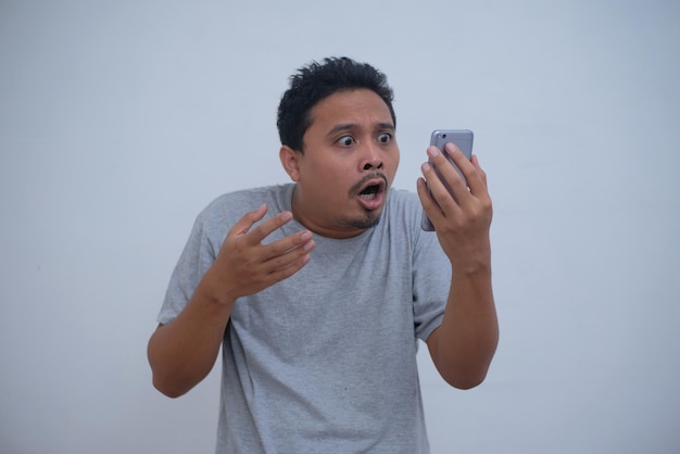 Funny shocked reaction of man looking his phone