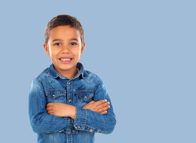 Divertente bambino piccolo con i capelli scuri e gli occhi neri che incrociano le braccia