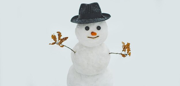 Funny snowman on a blurred snow background snowman with hat