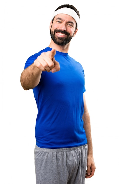 Funny sportsman pointing to the front on isolated white background