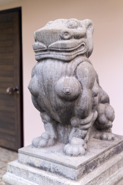 Funny statue of a stone lion at the entrance to the house