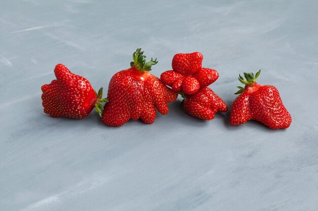 Funny strawberry berries. Trendy food. Eating ugly fruits and vegetables.