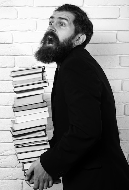 Photo funny teacher or professor with book stack thinking serious mature teacher falling books concept