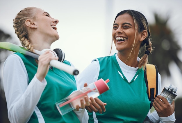 Photo funny team sports or women in conversation on turf or court for break after fitness training or exercise smile happy friends or female hockey players walking laughing or talking to relax together