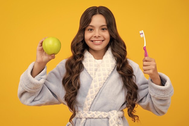 Funny teen girl brush her teeth dental healthy concept isolated over yellow background healthy kids teeth apple vitamins for healthy teeth oral medical and stomatology concept