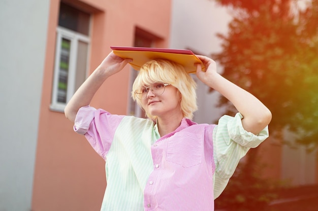 Funny teenage girl holding folders on her head