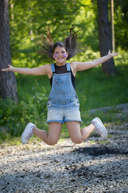 화창한 날에 공원에서 점프하는 재미있는 십대 소녀