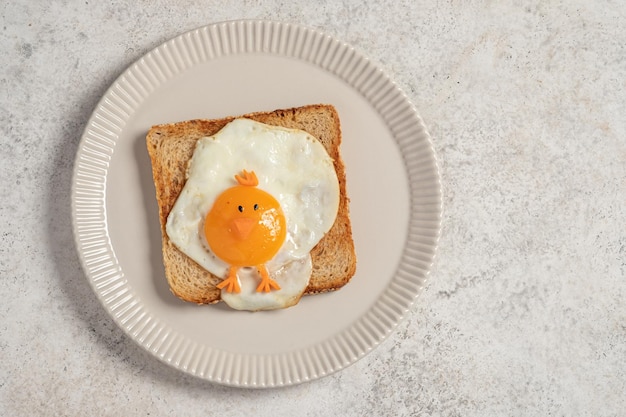 Funny toast with fried eggs in a shape of chicken