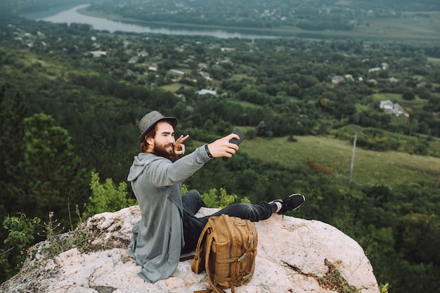 Foto il viaggiatore divertente prende selfie