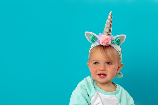 Funny unicorn little girl on blue background