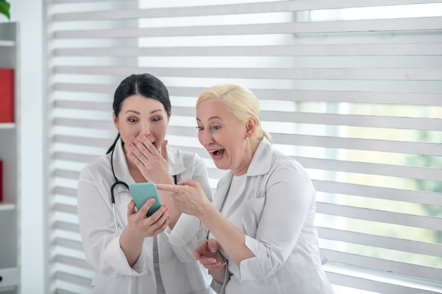 Funny video. Two doctors in white robes laughing together