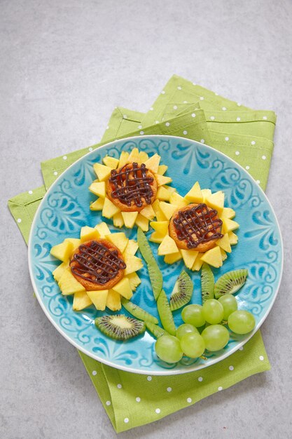 Funny wafer sunflowers with kiwi, grape, and peaches