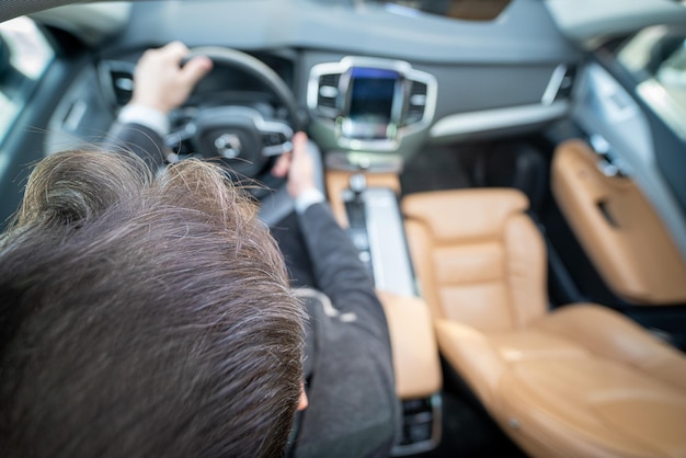 Funny wide angle of a male driver in luxury car