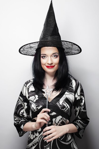 Funny Witch. Young happy woman with canival hat. Studio shot.