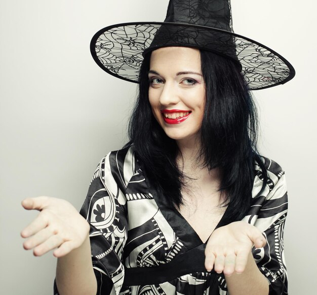 Funny Witch. Young happy woman with canival hat. Studio shot.