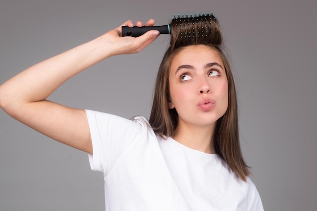 Funny woman brushing hair with comb beautiful girl with long hair hairbrush