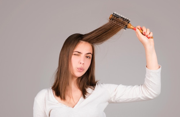 funny woman brushing straight natural hair with comb girl combing long healthy hair with hairbrush hair care beauty concept brushing hair
